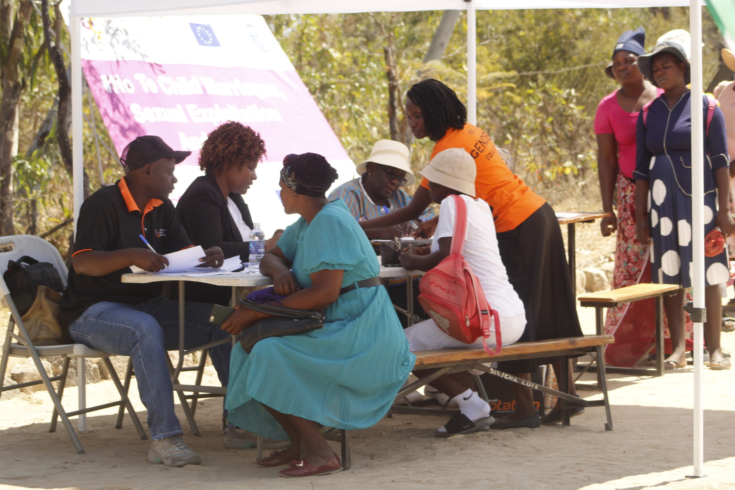 A counselor speaks with a man at a Zimbabwe mobile one-stop centre for gender-based violence survivors, highlighting the growing number of men reporting abuse by women.